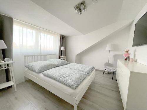 a white bedroom with a bed and a desk at F10 APARTMENT Illertissen SKY in Illertissen