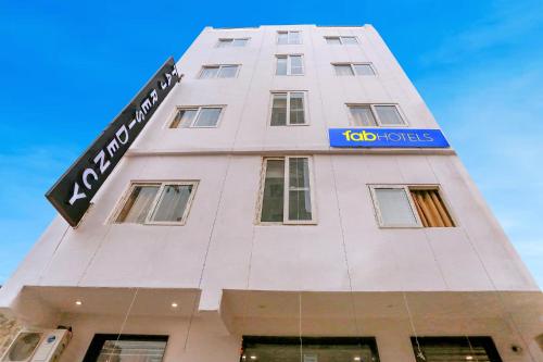 un edificio blanco alto con un letrero azul. en FabExpress Taj Residency en Nueva Delhi