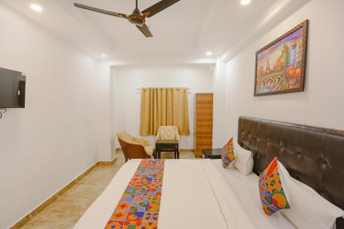 a bedroom with a bed and a ceiling fan at FabExpress Taj Residency - Nr Yashobhoomi Convention Centre in New Delhi
