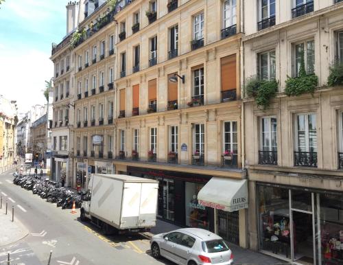 er staat een vrachtwagen voor een gebouw geparkeerd bij Appartement Familial Au Coeur du Marais in Parijs