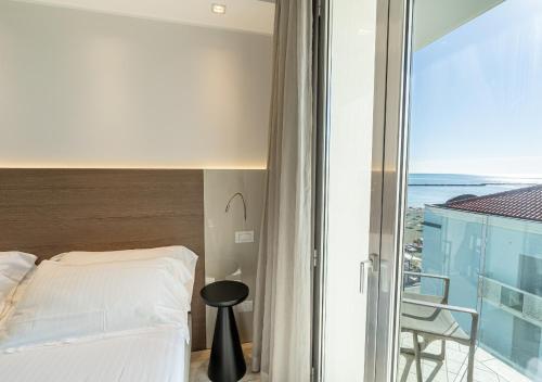 a bedroom with a bed and a view of the ocean at Hotel Savini in Bellaria-Igea Marina