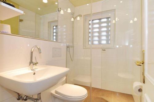 ein Bad mit einem Waschbecken, einem WC und einer Dusche in der Unterkunft Wohnung Sylter Brise in Wenningstedt-Braderup