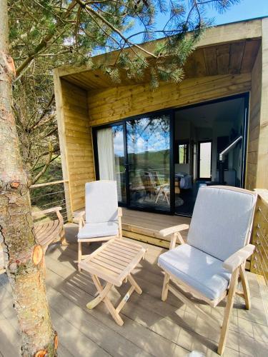 two chairs and a table on the deck of a house at Valley View Pendle in Foulridge