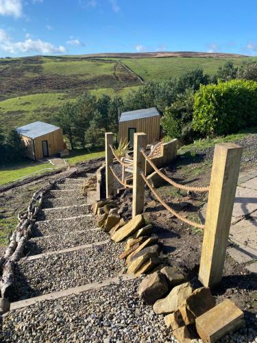 a stone path with a fence and some buildings at Valley View Pendle in Foulridge