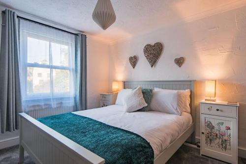 a bedroom with a bed with hearts on the wall at Brook Cottage in Temple Ewell