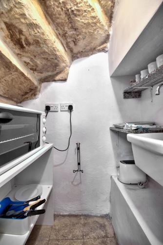 uma cozinha branca com um lavatório e um WC em Augustinian em Valletta