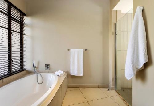 bagno bianco con vasca e doccia di Sofala Lodge a Mokopane