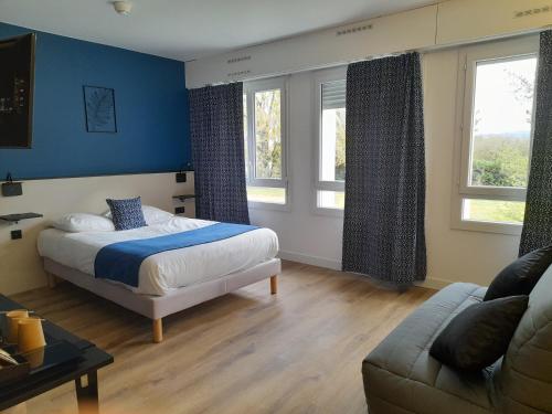 1 dormitorio con paredes azules, 1 cama y 1 sofá en Le Riccoty, en Blyes