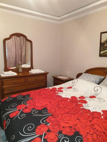 a bedroom with a bed with red roses on it at Alin Apartament in Iaşi