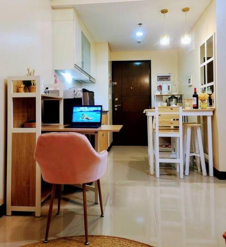 a kitchen with a desk with a laptop and a chair at House of B&Y at 101 Newport across NAIA T3 in Manila