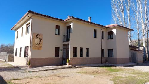 a large white house with black windows at Hostal-Casa Rural Rosa-Nonna in Sigüenza