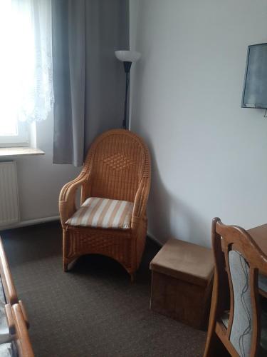 una sedia e uno sgabello in vimini in una stanza di Hotel Olimpijski a Tarnowskie Góry