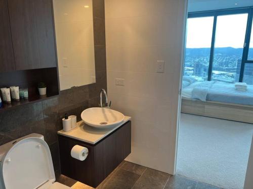 a bathroom with a sink and a toilet and a window at Amazing views 60th level skytower 3 bedrooms in Brisbane