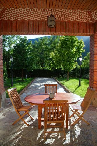 a wooden table and chairs under a pavilion at La Torre de Guardiola in Guardiola de Berguedà