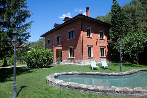 a house with two chairs and a pool in front of it at La Torre de Guardiola in Guardiola de Berguedà