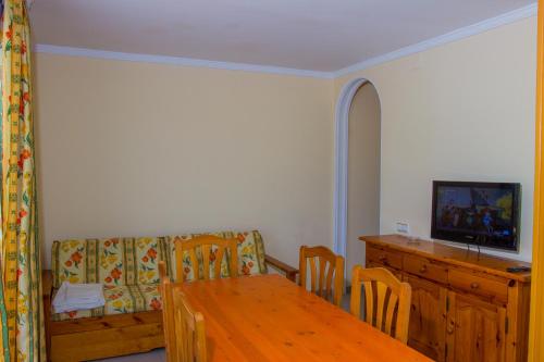 a living room with a wooden table and a couch at Rentalmar Arquus Park in Salou