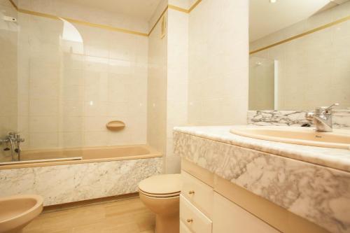 een badkamer met een wastafel, een toilet en een bad bij Arquus Park in Salou