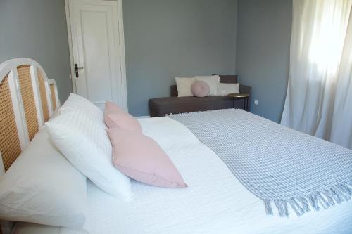a bedroom with a bed with pink and white pillows at La Torre de Guardiola in Guardiola de Berguedà