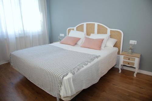 a bedroom with a large white bed with pink pillows at La Torre de Guardiola in Guardiola de Berguedà