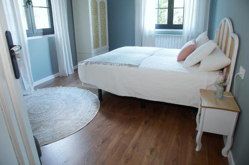 a bedroom with a bed with white sheets and pillows at La Torre de Guardiola in Guardiola de Berguedà