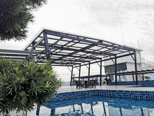 a pavilion over a pool with a table and chairs at Coco HomeStay 旅人の家@The Venus Sitiawan Perak in Sitiawan