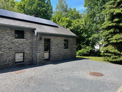 a brick building with a parking lot in front of it at Le Hérou in Houffalize