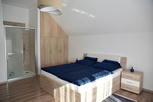 a bedroom with a large bed with blue pillows at Apartmán Lukov in Lukov