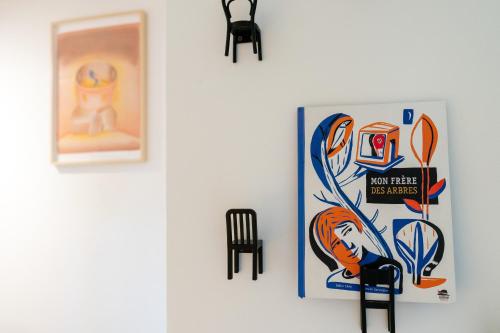 a wall with a poster and a chair on a wall at Au four et au jardin in Namur