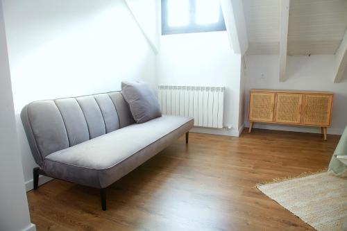 a couch in a living room with a wooden floor at La Torre de Guardiola in Guardiola de Berguedà