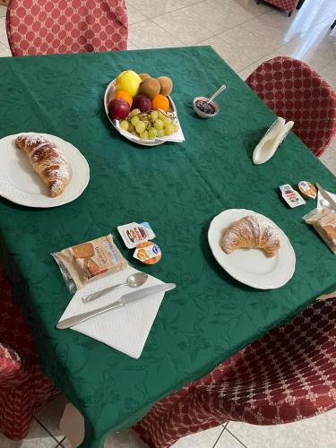 - une table verte avec des assiettes de pâtisseries et des fruits dans l'établissement B&B The King, à Acconia