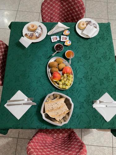 a green table with plates of food on it at B&B The King in Acconia