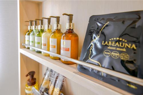 a shelf with a bunch of bottles of alcohol at Hotel BaliBali 伊勢佐木 in Yokohama