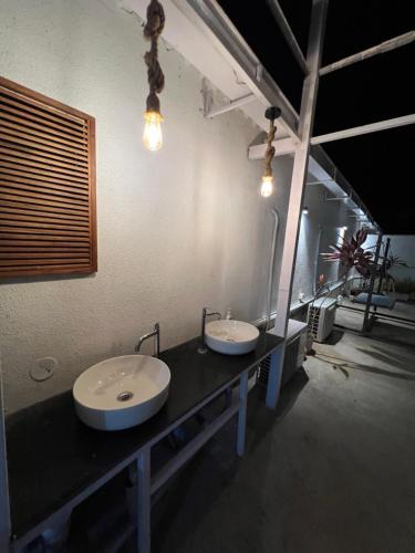 ein Badezimmer mit zwei Waschbecken auf einer schwarzen Theke in der Unterkunft Shree Bharadi Home Stay in Alibag