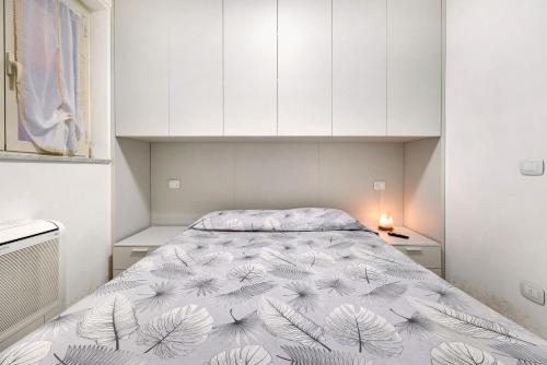 een slaapkamer met een bed en witte kasten bij Condomino Alba Chiara 6 in Loano