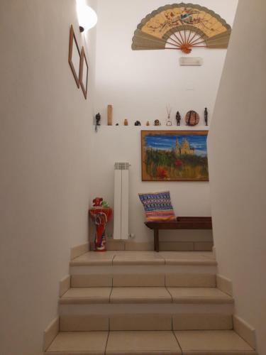 a staircase with a painting and a bench on the wall at La mansarda di Daniela in Montepulciano Stazione