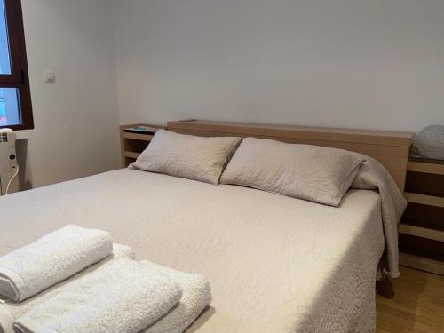 a bedroom with a bed with two pillows on it at Ático dos dormitorios en el centro de Córdoba in Córdoba