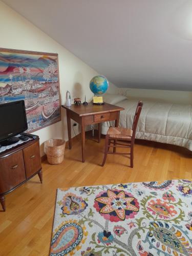 a room with a desk and a bed and a table with a globe at La mansarda di Daniela in Montepulciano Stazione