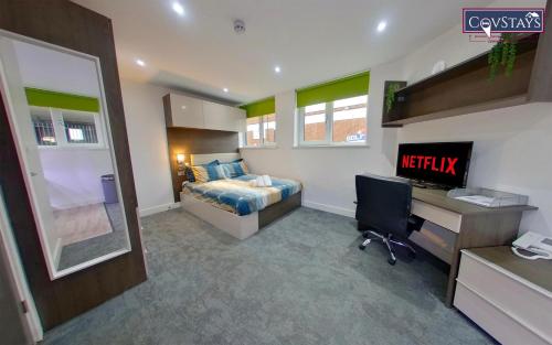 a bedroom with a bed and a desk with a computer at New House - Magnificent Studios in Coventry City Centre, free parking, by COVSTAYS in Coventry