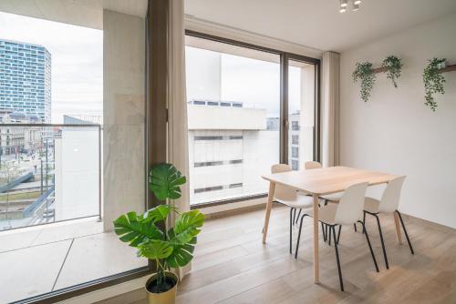 een eetkamer met een tafel en stoelen en een groot raam bij Opera Square Apartments in the Center of Antwerp in Antwerpen