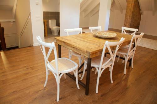 a dining room table with white chairs around it at La Torre de Guardiola in Guardiola de Berguedà