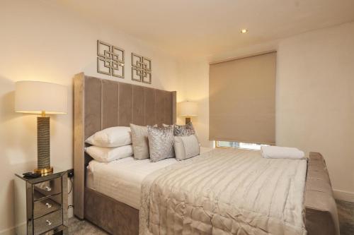 a bedroom with a large bed with a large headboard at Deluxe City Apt, Beautiful River View&Free Parking in Leeds