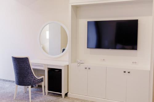 a room with a desk with a tv and a mirror at Muller Hotel Boutique & Spa in Galaţi