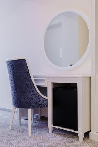 a desk with a chair and a mirror at Muller Hotel Boutique & Spa in Galaţi