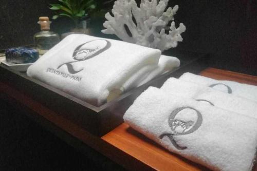 drei Handtücher liegen auf einem Holztisch. in der Unterkunft Quinta Vale das Papas in Casal de Loivos