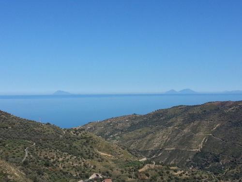 a view of the ocean from atop a mountain at L'Uliveto in Reitano
