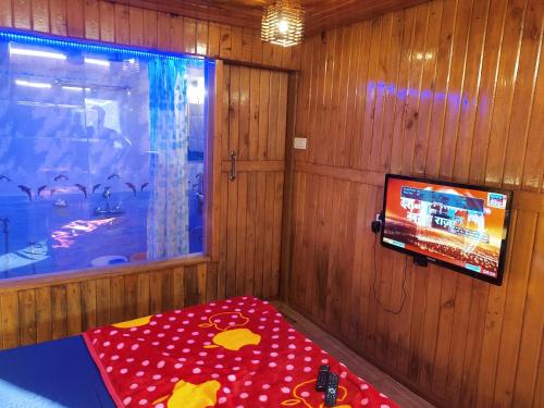 um quarto com uma televisão e uma mesa com uma mesa sidx sidx em altafs motel em Matheran