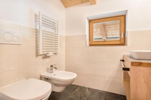 a white bathroom with a toilet and a sink at Hatzes App Raschötz in Laion