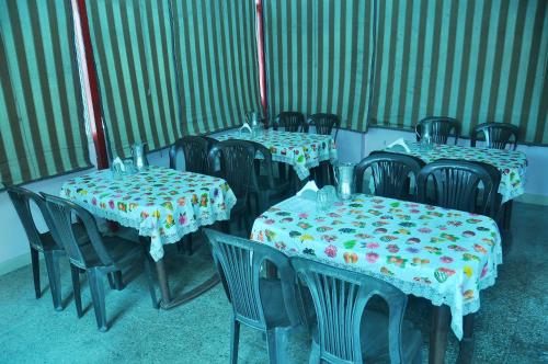 a group of tables and chairs in a room at Hotel Thikana Palace in Jaipur