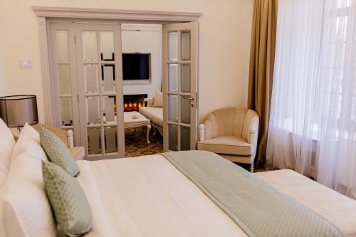a bedroom with a bed and a living room with a fireplace at Muller Hotel Boutique & Spa in Galaţi