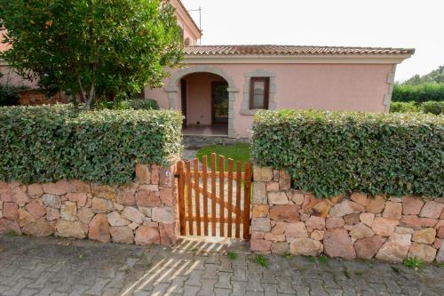 a fence in front of a stone wall at Ville del Mar in San Teodoro